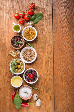 Different spices and vegetables in bowl on a wooden table. italian food ingredients. top view. copy space for textの写真素材