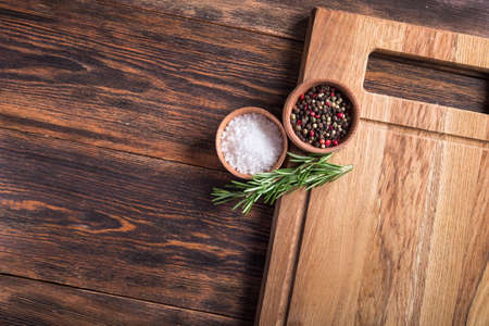 Closeup of spices salt and black papper, rosemary in bowl on a wooden table. top view. copy space for textの写真素材