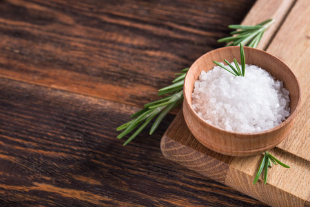 Close-up of salt with rosemary in bowl on a wooden table. copy space for textの写真素材