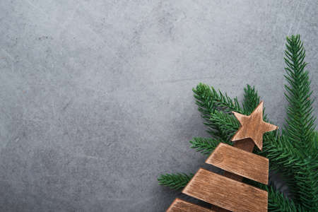 Decor wooden fir tree with branches on a stone background. Concept of Merry Christmas holiday. Top view. Flat Lay.の写真素材