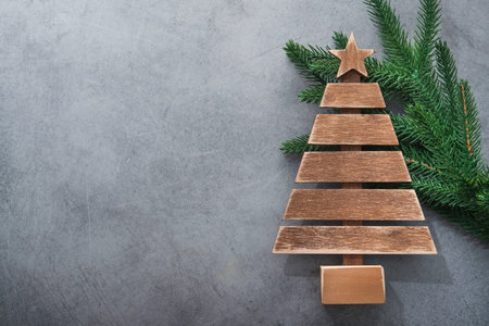 Decor wooden fir tree with branches on a stone background. Concept of Merry Christmas holiday. Top...