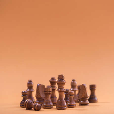 Group of chess wooden pieces on brown background. format squareの写真素材