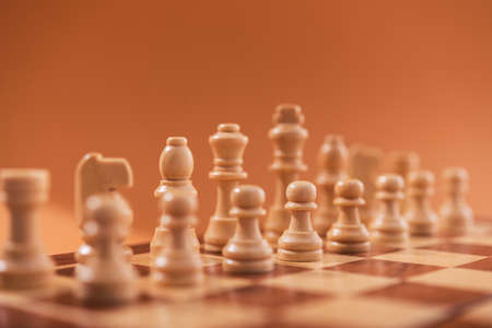Wooden chess pieces on a brown background.の写真素材