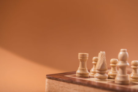 Wooden chess pieces on a brown background.