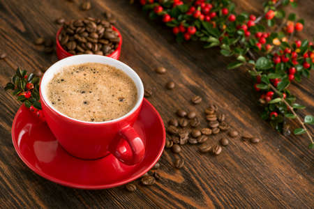 Delicious brazilian arabica coffee in red cup with berries on a wooden table.の写真素材
