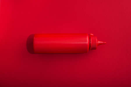 Plastic containers with ketchup and mustard on red background. fast food concept. top viewの写真素材