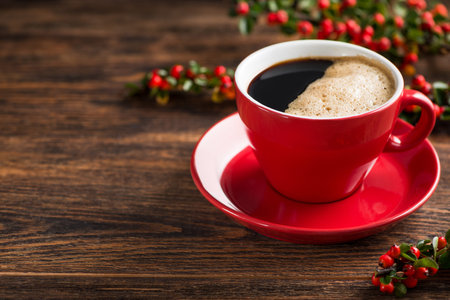 Delicious brazilian arabica coffee in red cup with berries on a wooden table.