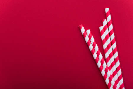 Bright colored cocktail straw on a color red background. recycling eco concept. minimal style. flat lay. topの写真素材