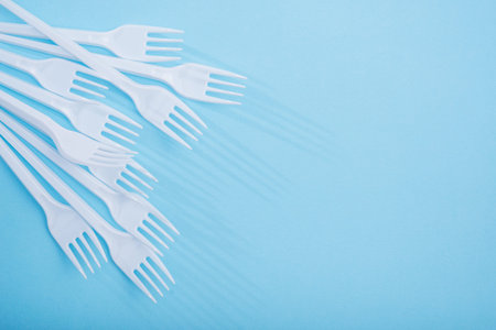 Creative concept of reducing the use of plastic tableware on a pastel color background.