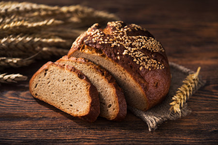 Tasty rye bread with sesame on a wooden background.