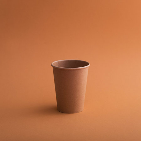 Empty paper coffee cup on a brown background. Pop art or minimal style. Paper recycling.