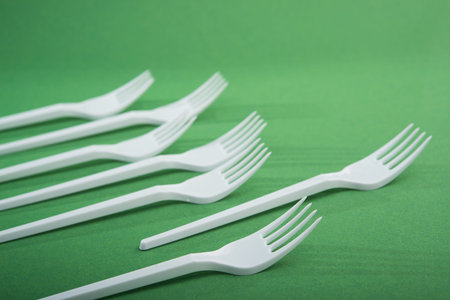 Creative concept of reducing the use of plastic tableware on a pastel color background.