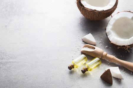 Organic coconut oil in a small glass bottle on a gray