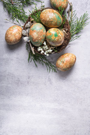 Marble color decoration Easter eggs with flowers in nest. top view