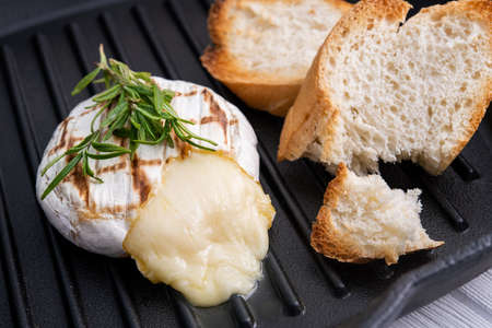Grilled camembert cheese on a pan surfaceの写真素材