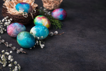 Easter holiday concept with colored space egg on a dark stone background. Copy space.