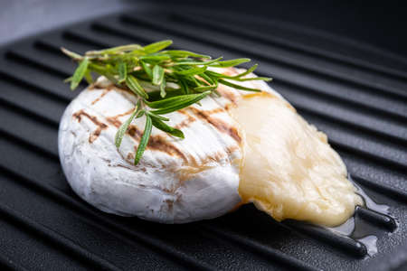 Grilled camembert cheese on a pan surfaceの写真素材