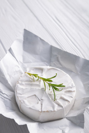 Fresh raw brie cheese on a wood white background