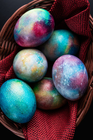 Mystical coloring eggs in the basket. Easter holiday greeting card background. Top view.