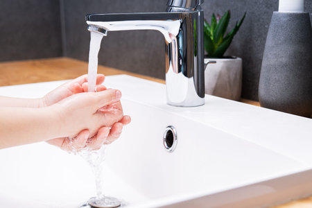 Child washing hands with soap in the bathroom. prevention and protection of coronavirus pandemic...
