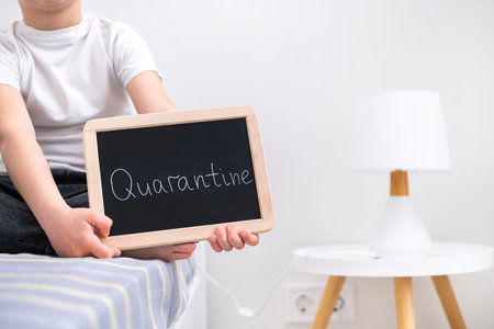 The child is quarantined in his room. Quarantine sign in hand.