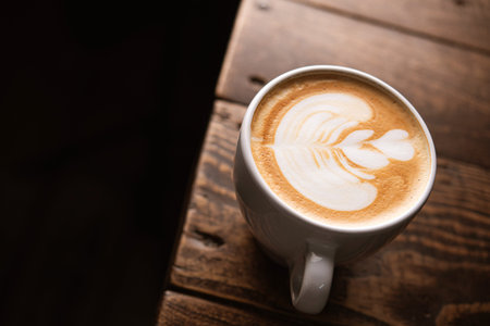 Tasty coffee cappuccino art foam on a wooden table. top view
