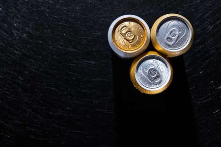 Top view of wet beer cans on black background.の写真素材