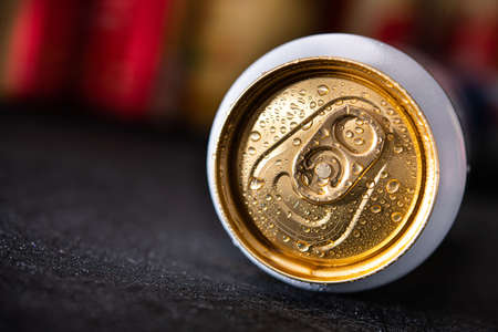 Wet unopened beer cans with drops lie in the dark background. refreshing cold drinkの写真素材