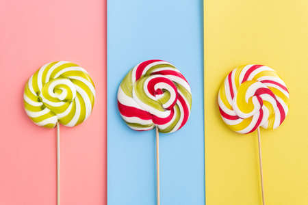 Lollypops candy in trend pastel colors. Pop Art. Summer kids food. Minimal wallpaper. Flat Lay. Top view.の写真素材