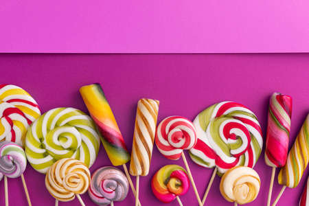 Lollypops kids food on a trend violet color background. pop art concept. top view. place for text. flat lay.の写真素材