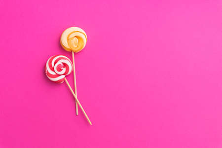 Two lollipops trend food on a pink background. Pop Art. Top view. Summer bright sweets.の写真素材