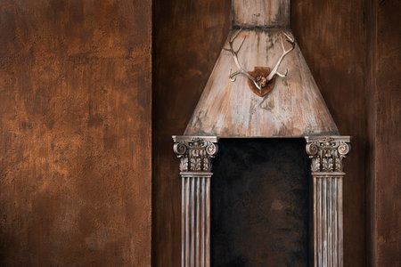 An old vintage hunting room and a wall with a fireplace made of columns, deer antlers hanging like a trophy.の写真素材