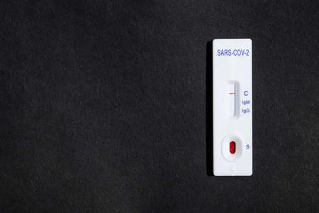Rapid Covid-19 test. Coronavirus pandemic. Negative virus test on a black background. Top view.の写真素材