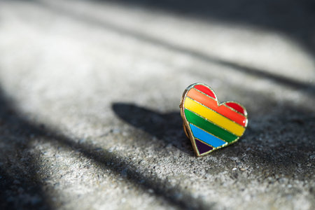 Badge heart lgbt colors lies on the asphalt. Support lesbian and gay concept background.