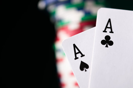 Successful first hand in poker game, pair of aces on a casino table background.