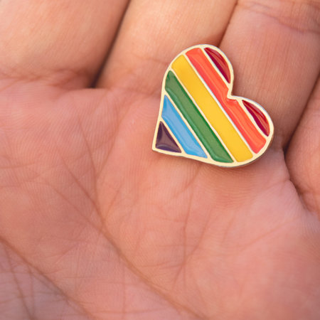 Colorful rainbow heart-shaped icon in hand
