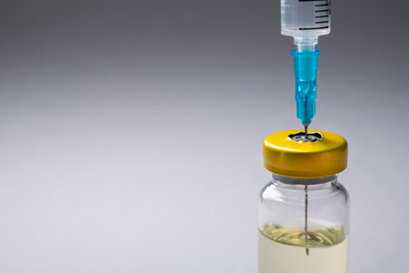 Closeup of glass bottle with coronavirus medication. Laboratory studies of the vaccine. White background table. Vaccine development.の写真素材