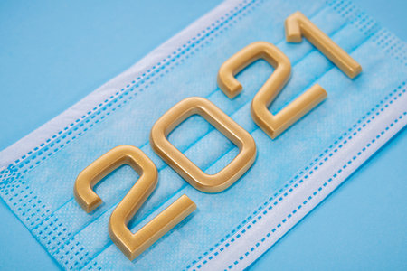 Medical mask against coronavirus. Vaccination begins in 2021. The numbers are golden. Blue...
