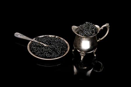 Black sturgeon caviar in retro vintage dish isolated on a black background. seafood diet foodの写真素材