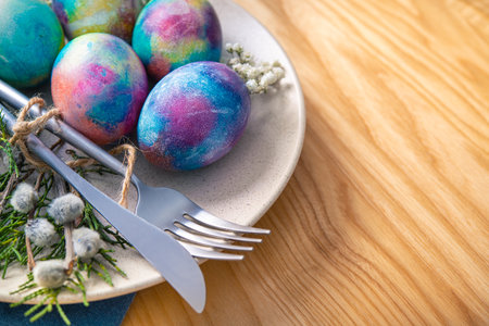 Easter table setting with eggs and forest wild flowers on a wooden tableの写真素材
