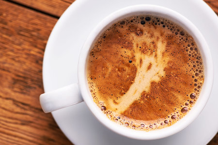 Coffee cup on a wooden table. Top view. Closeup foam.