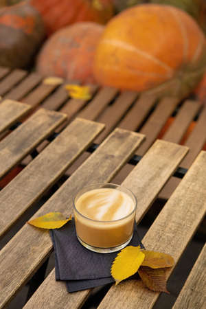 Cup of tasty coffee on a wooden table, pumpkins on background. hanksgiving holiday concept.の写真素材