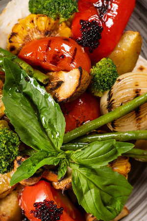 Delicious grilled vegetables tomato, onion, corn, mushrooms. top view. Basil leaves.の写真素材