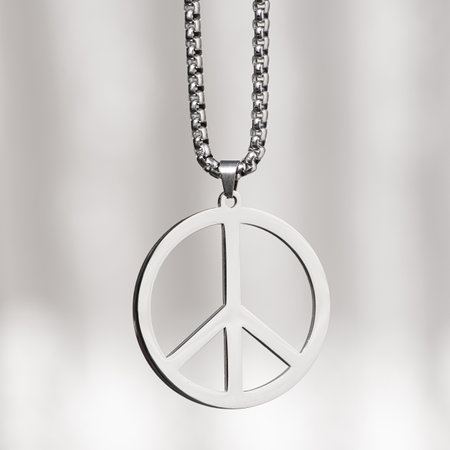 Metal peace symbol necklace medallion on a white. Stop war in Ukraine background.の写真素材