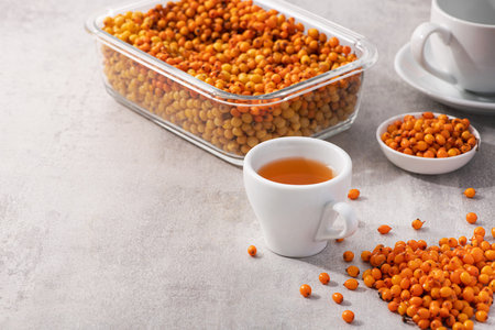 Sea buckthorn tea in a white cup. healthy and useful vitamin drink background.