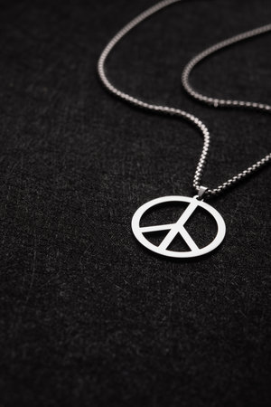 Necklace with a mark of peace on a black old background. Stop war in Ukraine. Anti war concept.の写真素材