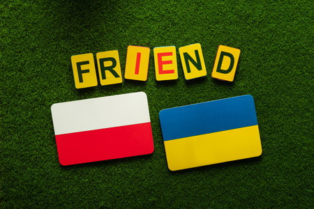 Flags of Poland and Ukraine on a green lawn. friendship and partnership in war. support background. top view.の写真素材