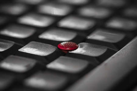 Red dot laptop keyboard with blurry image aroundの写真素材
