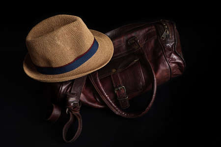 A jazz brown hat with duffel brown bag with black backgroundの写真素材