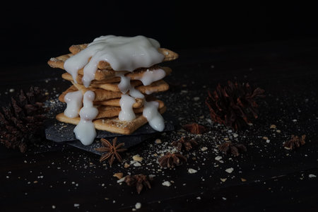 Melting plain yogurt on a pile of crackers with black background, dark food conceptual photo